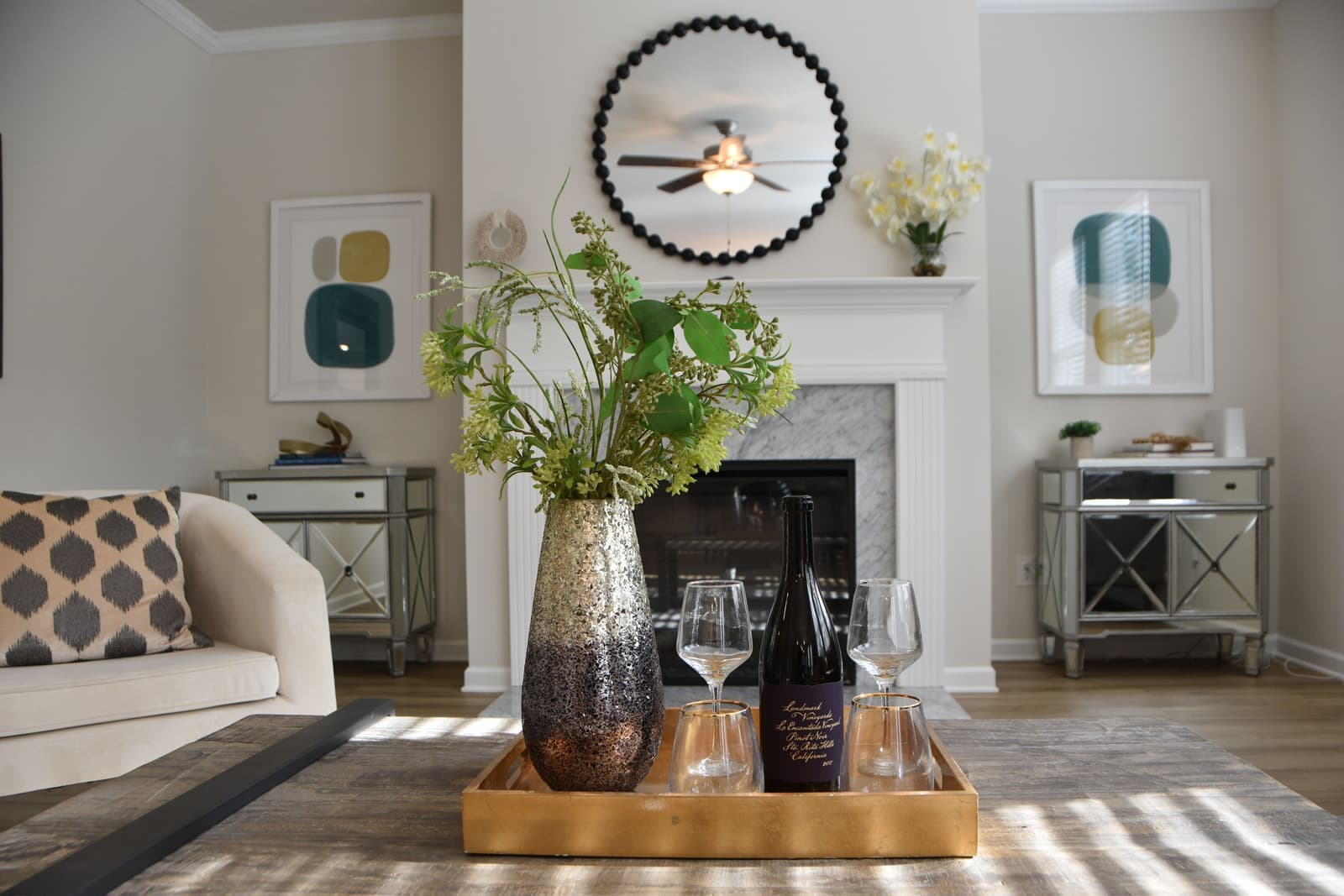 Bottles and glasses arranged on a tray in a bright living room