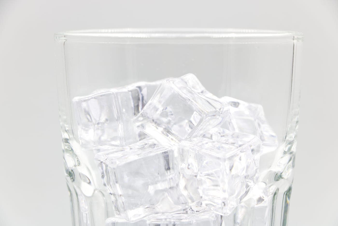 Clear ice cubes in a glass in bright daylight